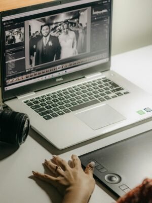 A person processes wedding photos on a laptop using a graphics tablet, showcasing digital editing tools.